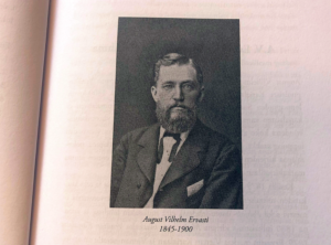 Mustavalkoinen kuva parrakkaasta miehestä ja sen alla on teksti August Vilhelm Ervasti 1845-1900