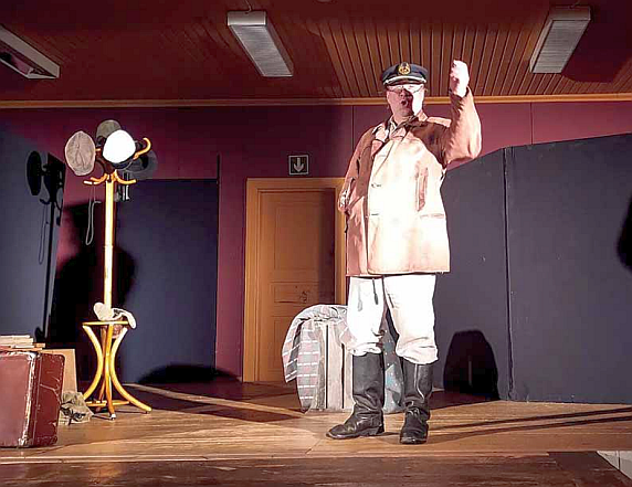 Mies pitää monologia teatterin lavalla