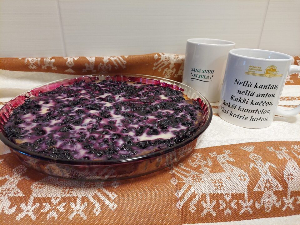 Mustikkapiirakka ja kaksi kuppia pöydällä