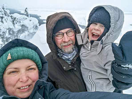 Mies, nainen ja poikalapsi talvivaatteissa