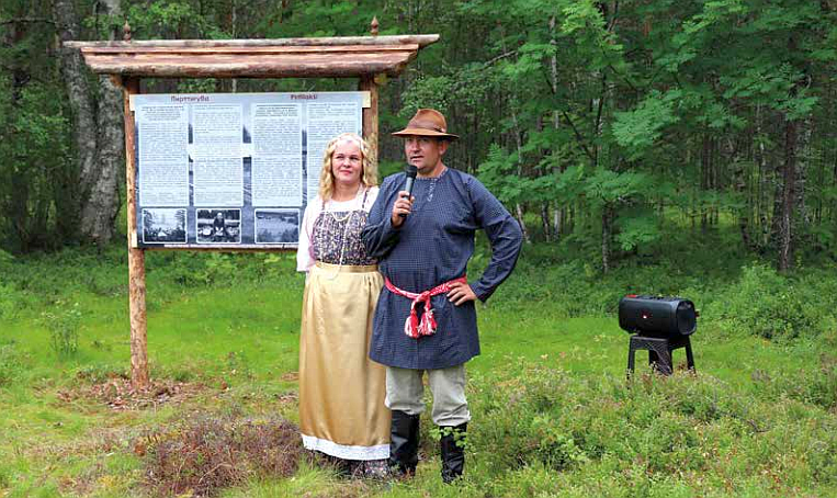 Mies ja nainen seisovat kyltin edessä.