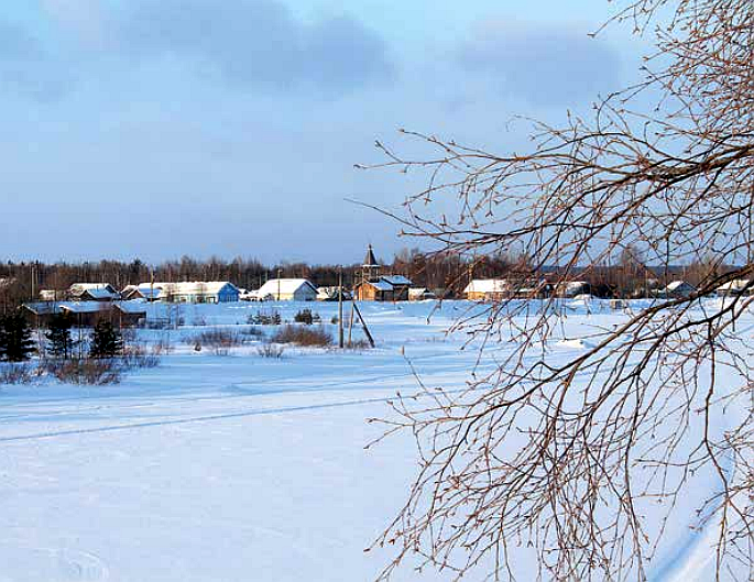 Talvinen maisema järven yli pieneen kylään