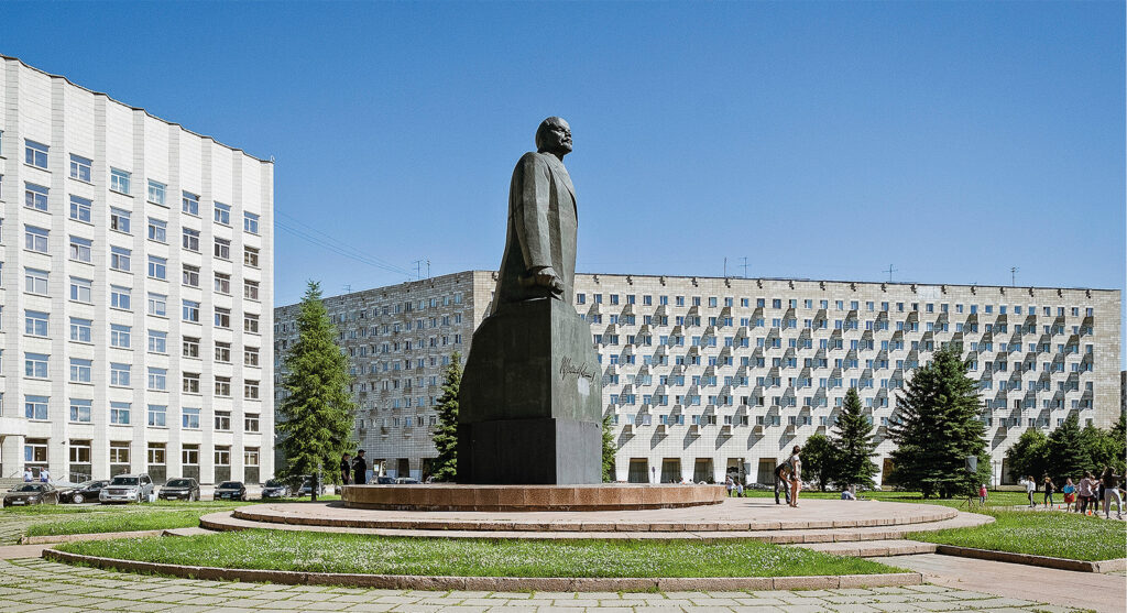 Leninin patsas keskellä aurinkoista aukiota.