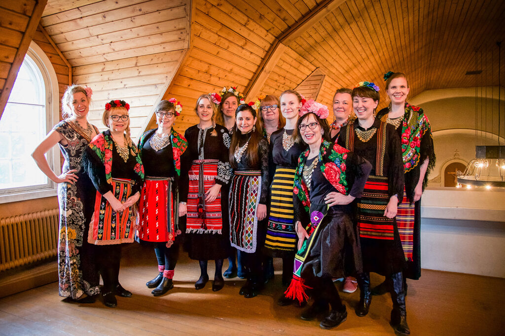 Kuorolaulajia ryhmäkuvassa.