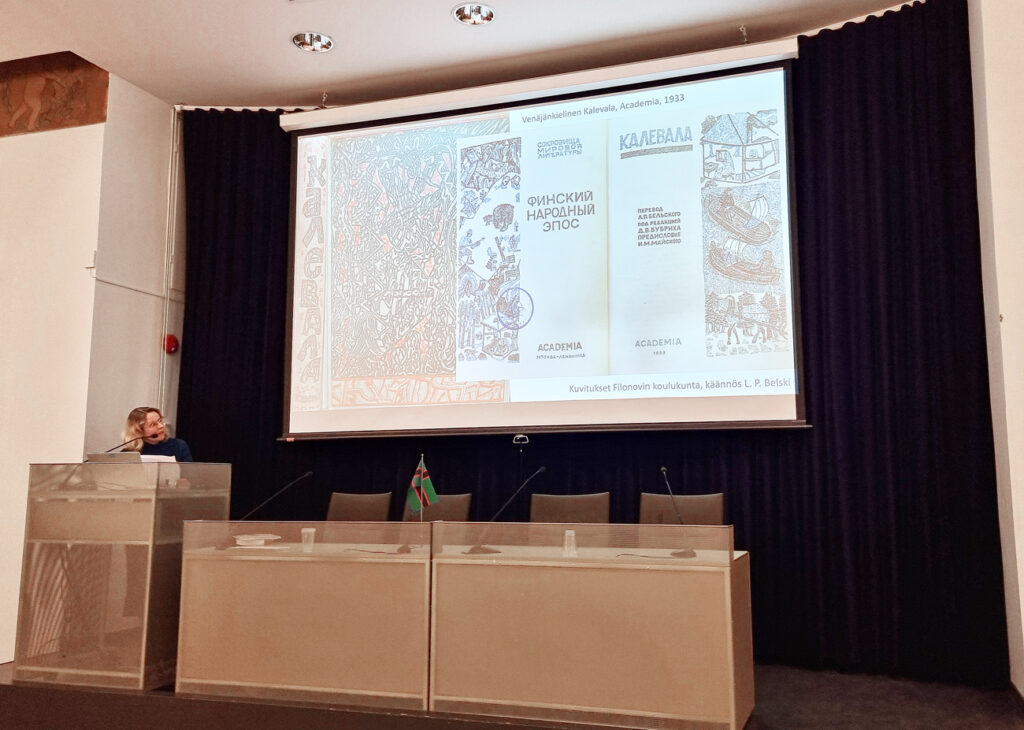 Suurella valkokaankaalla näkyy venäjänkielisen Kalevalan graafisia kuvitussivuja.