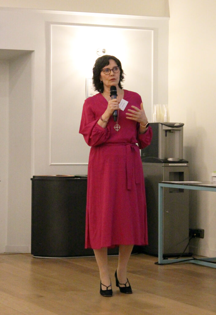 Nainen puhuu mikrofoniin.