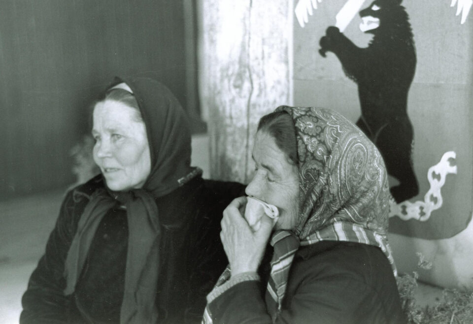 Kaksi huivipäistä naista vanhassa mustavalkokuvassa, toisella on itkuliina posken peittona.