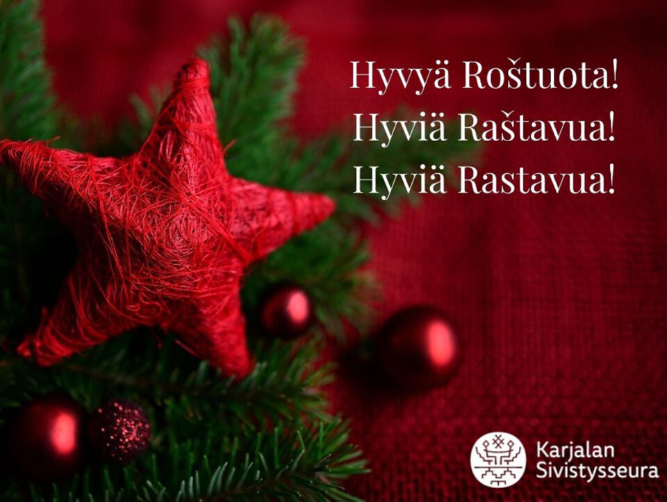 Punaisella taustalla vihreitä kuusenoksia, joissa punainen tähti ja punaisia kuusenkoristepalloja.