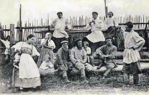 Ryhmä nuoria pihalla, taustalla puuaita