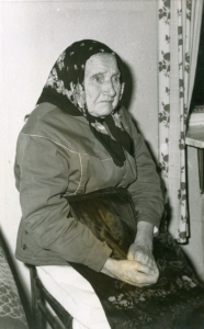 Mustavalkoinen kuva iäkkäästä naisesta huivissa